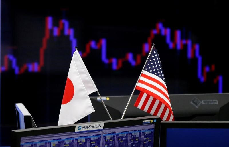 © Reuters. FILE PHOTO - National flags of Japan and the U.S. are seen in front of a monitor showing a graph of the Japanese yen's exchange rate against the U.S. dollar at a foreign exchange trading company in Tokyo