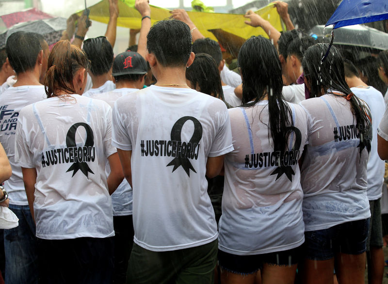 © Reuters. Friends of John Jezreel (JJ) David, 21, who was shot dead in what police said was an anti-drug operation, wear white t-shirts calling for the "Justice for JJ" during his funeral rites at the north cemetery in Metro Manila