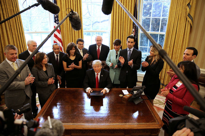 © Reuters. U.S. President Donald Trump signs an executive order cutting regulations, accompanied by small business leaders at the Oval Office of the White House in Washington U.S.