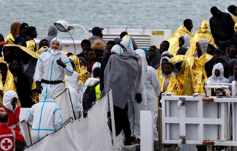 © Reuters. Migrants wait to disembark from Italian Coast Guard patrol vessel Diciotti in the Sicilian harbour of Catania