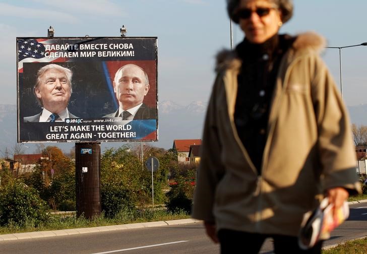 © Reuters. A woman passes a billboard showing a pictures of US president-elect Donald Trump and Russian President Vladimir Putin in Danilovgrad