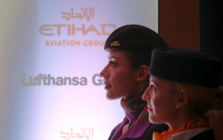 © Reuters. Hostesses attend a joint news conference by Etihad Aviation Group CEO James Hogan and Carsten Spohr, Chief Executive Officer of Lufthansa, in Abu Dhabi