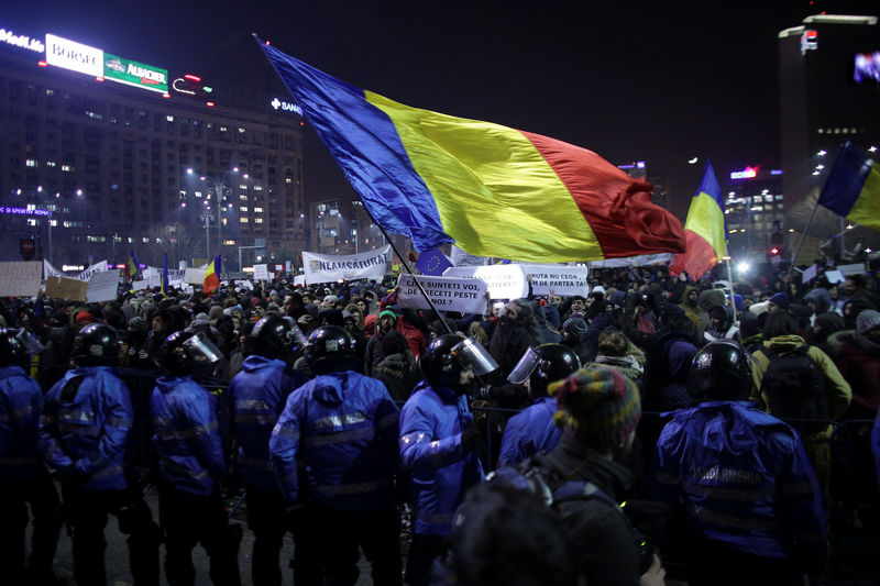 © Reuters. Protesters wave Romanian flag during a demonstration in Bucharest