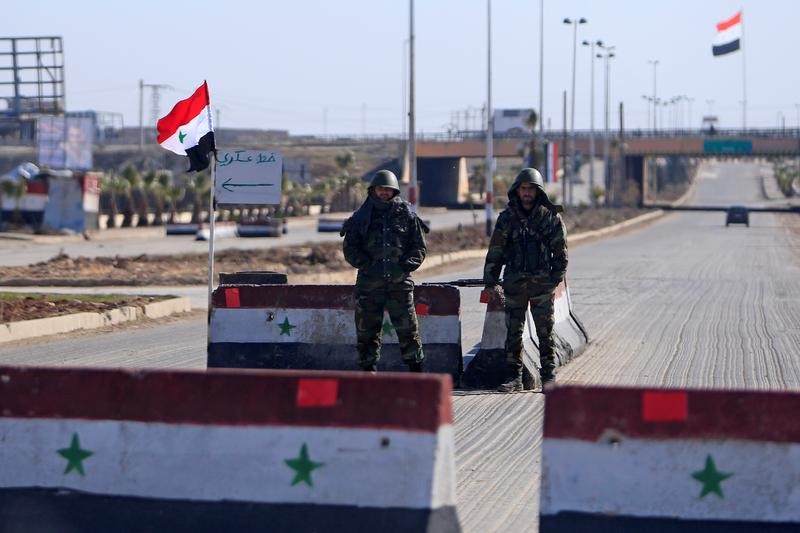 © Reuters. Syrian army soldiers man a checkpoint along a road in Aleppo