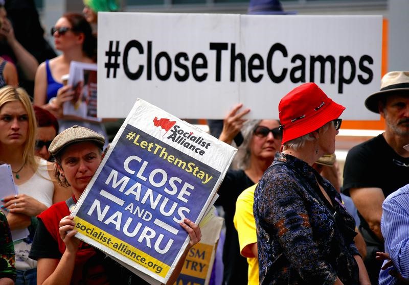 © Reuters. FILE PHOTO - Protesters from the Refugee Action Coalition hold placards during a demonstration outside the offices of the Australian Government Department of Immigration and Border Protection in Sydney, Australia