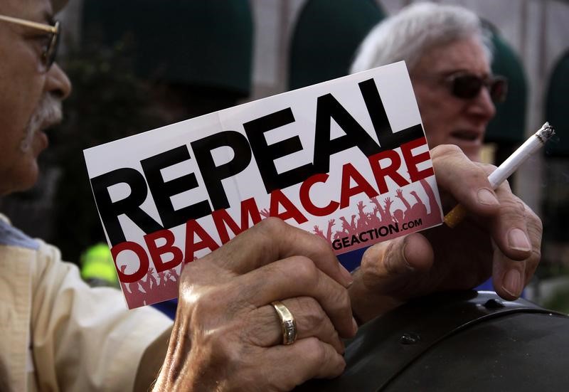 © Reuters. File photo of a demonstrator holding a pamphlet outside a "Defund Obamacare Tour" rally in Indianapolis