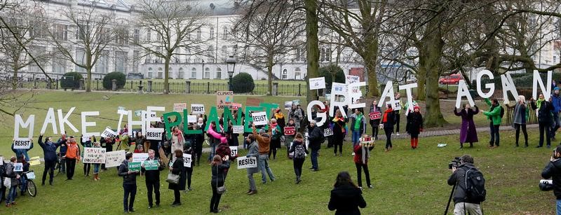 © Reuters. Environmental activists take part in a protest while Myron Ebell, who leads U.S. President Donald Trump's Environmental Protection Agency's transition team, arrives at the Solvay library in Brussels