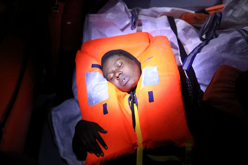 © Reuters. Mata, 23, from Nigeria, tries to recover after fainting during a rescue operation of 104 sub-Saharan migrants aboard a raft by the Spanish NGO Proactiva Open Arms, in the central Mediterranean Sea, 24 miles north of the coastal Libyan city of Sabratha