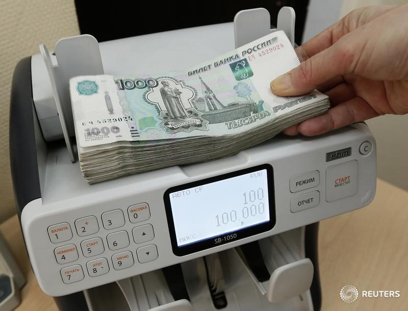 © Reuters. Кассир пересчитывает рублевые купюры в офисе в Красноярске