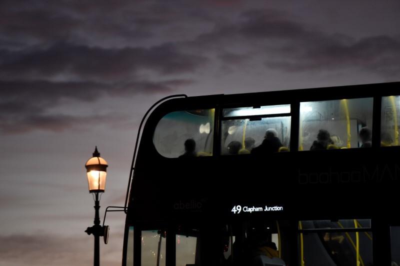© Reuters. A bus drives across a bridge as the sun sets over the Chelsea area in London