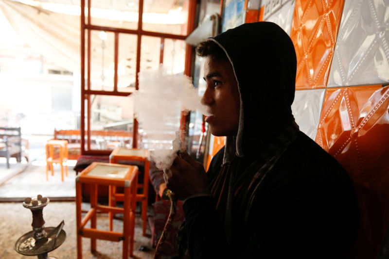© Reuters. An Iraqi man smokes waterpipe at a coffee shop in the street of Mosul