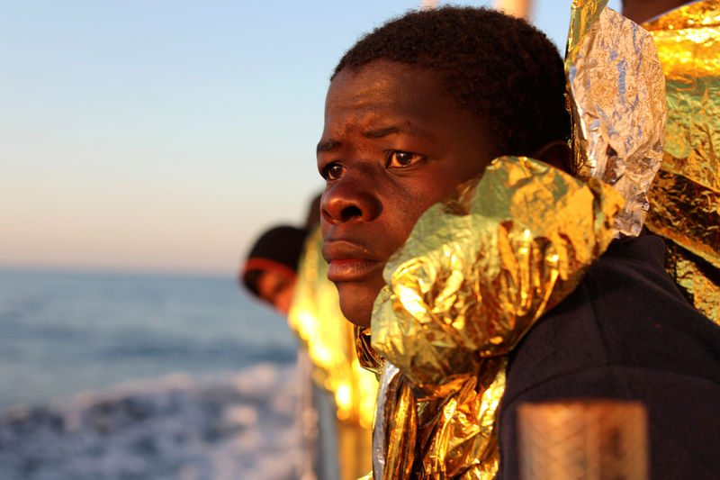 © Reuters. A migrant, covered with a thermal blanket, gazes at the sea aboard the former fishing trawler Golfo Azzurro of the Spanish NGO Proactiva Open Arms following a rescue operation near the coasts of Libya in the central Mediterranean Sea