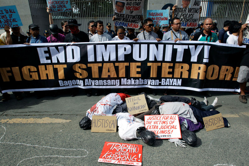 © Reuters. Effigies of corpses are seen with placards as activists protest during a rally outside the Philippine National Police (PNP) Headquarters in Quezon City, metro Manila