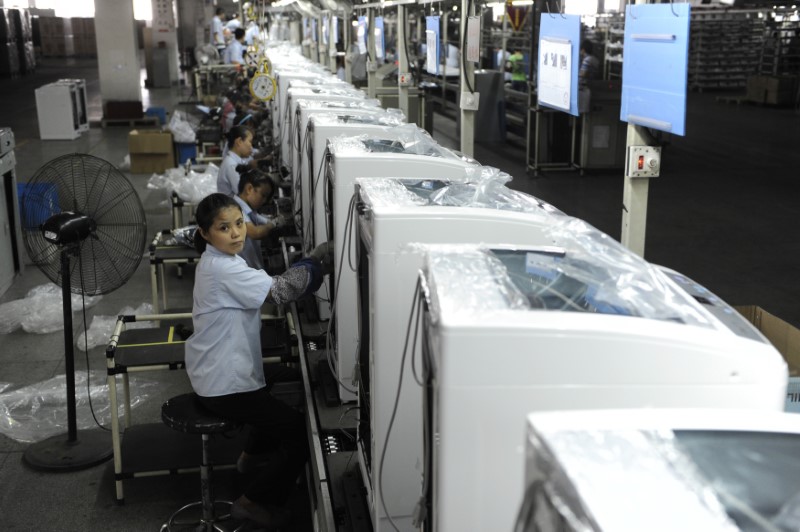© Reuters. Employees assemble washing machines on the production line inside a factory of Hefei Rongshida Sanyo Electric in Hefei