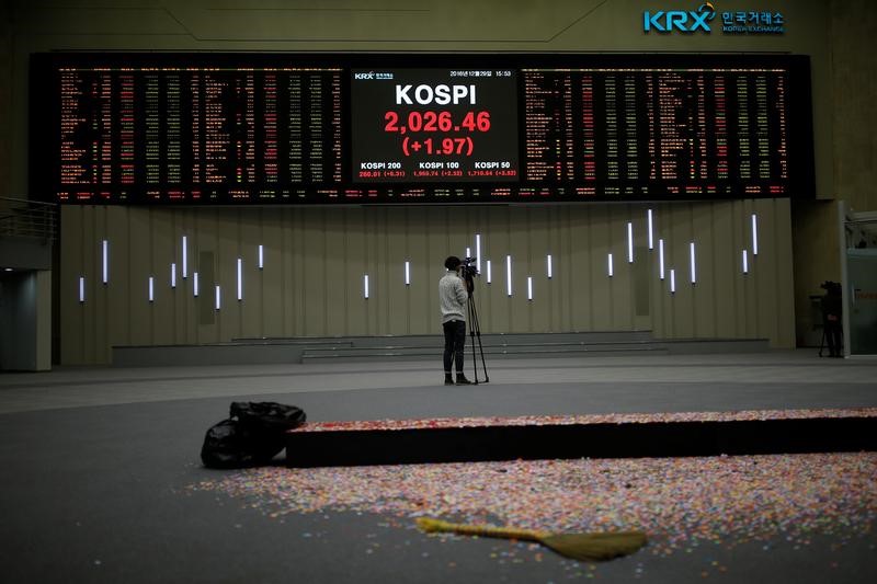 © Reuters. A journalist films the final stock price index after the ceremonial closing event of the 2016 stock market in Seoul