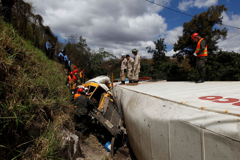 © Reuters. Rescue workers and soldiers trying to rescue people after a crash between a bus and a truck on the outskirts of Tegucigalpa, Honduras