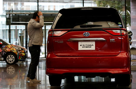 © Reuters. A man looks at Toyota Motor Corp's Estima Hybrid model at its headquarters in Tokyo