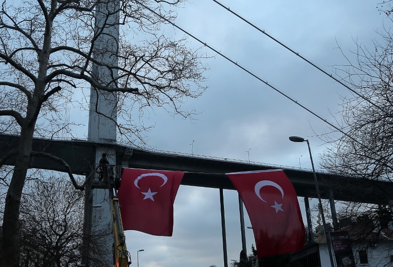 © Reuters. Worker attaches Turkish flags near the Reina nightclub by the Bosphorus, which was attacked by a gunman, in Istanbul