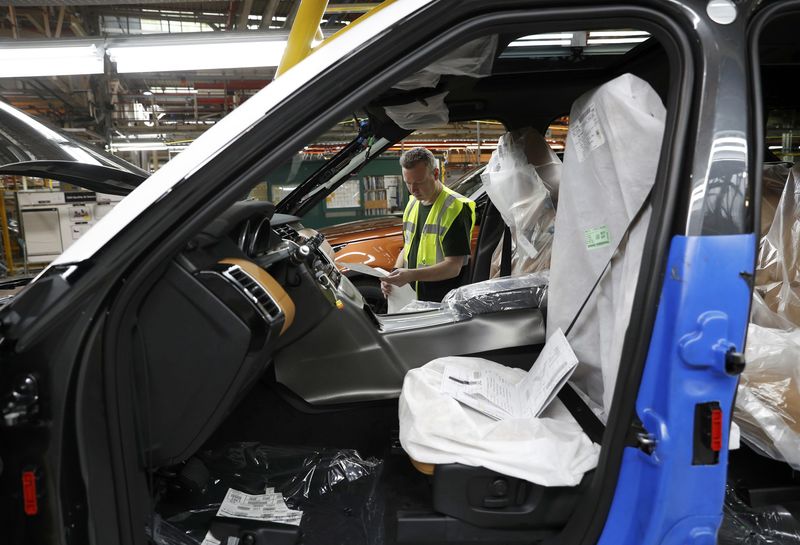 © Reuters. Worker George Baker looks at a build card for a vehicle destined for China at the Jaguar Land Rover facility in Solihull