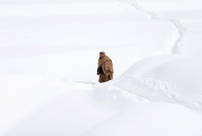 © Reuters. عمال الإنقاذ يحاولون الوصول لمناطق ضربتها انهيارات جليدية بأفغانستان