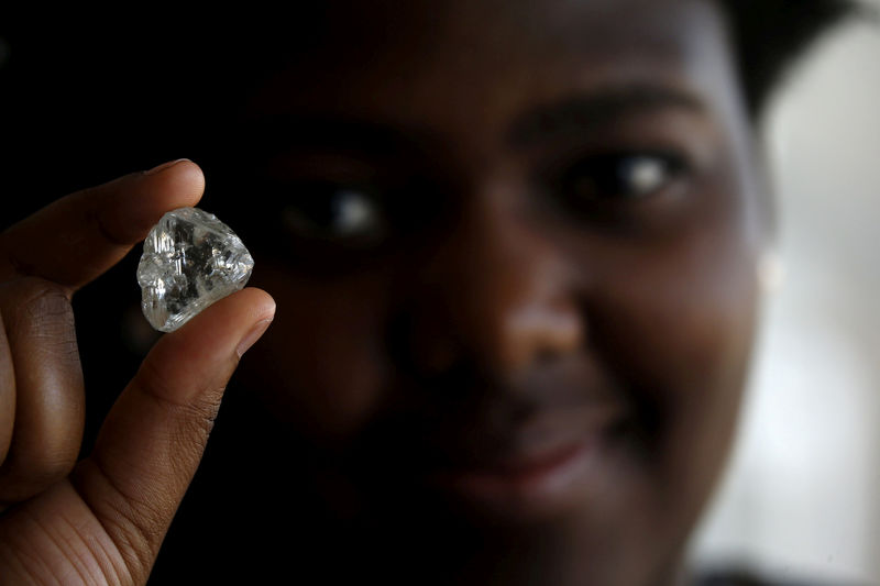 © Reuters. FILE PHOTO: A visitor holds a diamond during a visit to the De Beers Global Sightholder Sales (GSS) in Gaborone