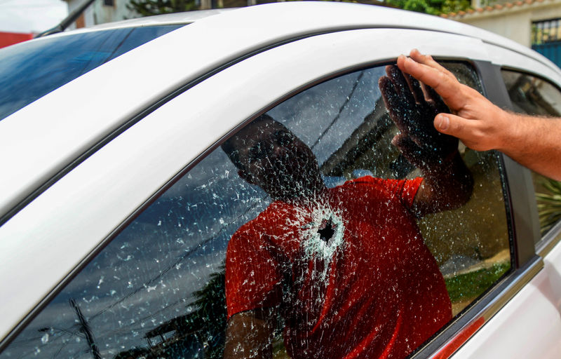 © Reuters. Homem observa janela de carro quebrada em Vitória