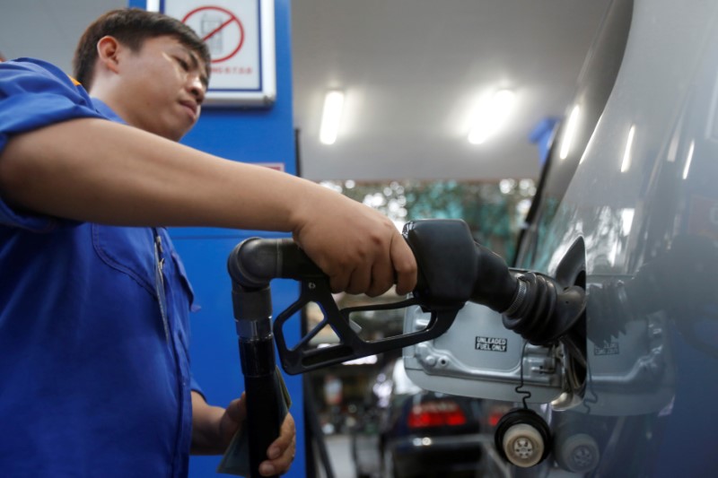 © Reuters. FILE PHOTO: An employee pumps petrol into a car at a petrol station in Hanoi