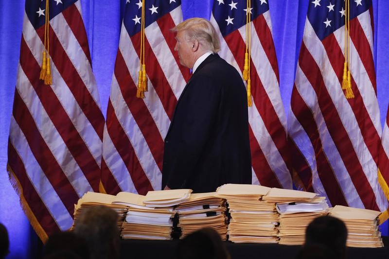 © Reuters. U.S. President-elect Donald Trump walks past a pile of papers during a news conference in the lobby of Trump Tower in Manhattan, New York City