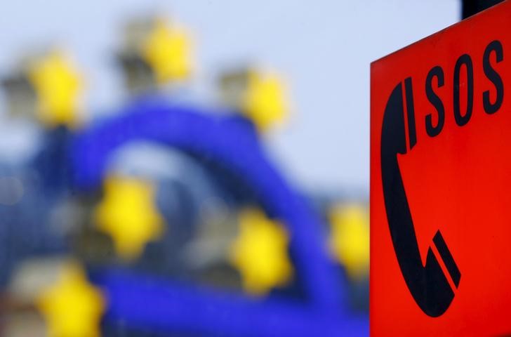 © Reuters. Телефон для связи с экстренными службами на фоне символа валюты евро у здания ЕЦБ во Франкфурте-на-Майне