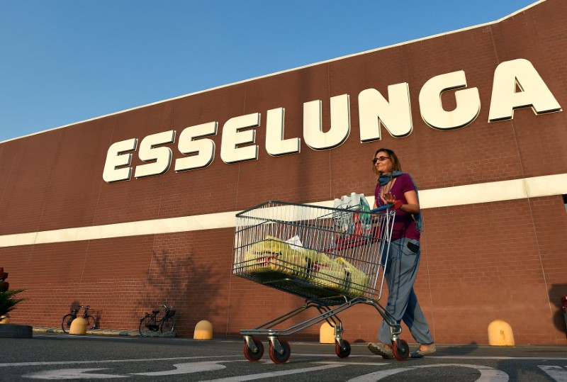 © Reuters. A woman pushes a shopping cart outside Esselunga supermarket in Pioltello near Milan
