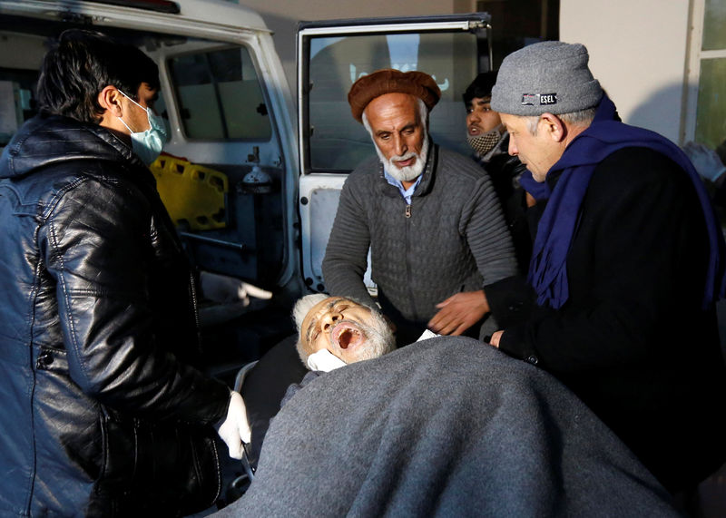 © Reuters. Men carry an injured man to a hospital after a bomb blast in Kabul