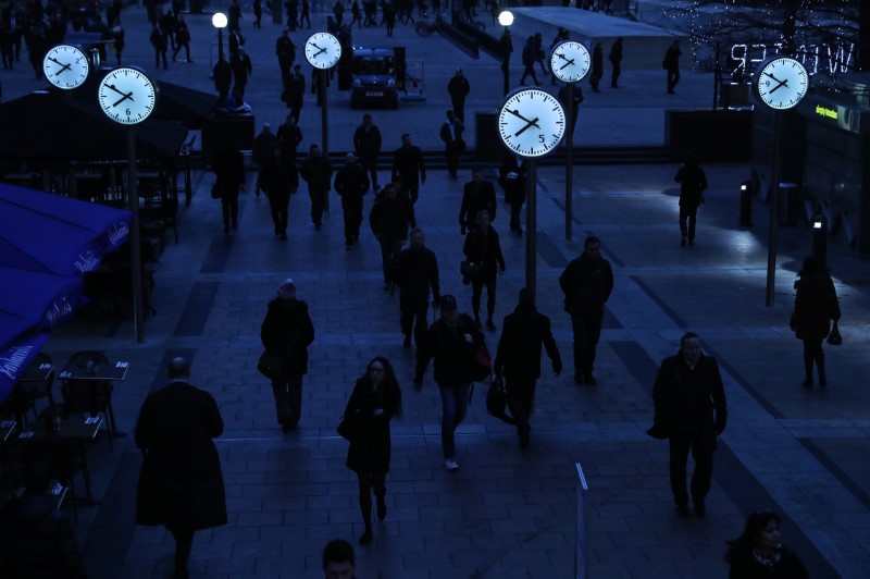 © Reuters. Workers walk to work during the morning rush hour in the financial district of Canary Wharf in London