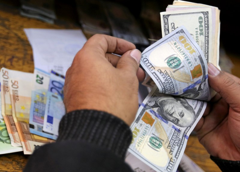 © Reuters. A man counts U.S dollars and Euros at a money exchange office in central Cairo