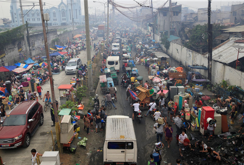 © Reuters. Fire victims gathers along a street after a fire in Parola Compound, Tondo city, metro Manila