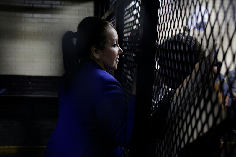 © Reuters. Guatemalan Supreme Court judge Blanca Stalling talks to unidentified persons while standing in a cage after being arrested on influence trafficking, at the Supreme Court of Justice in Guatemala City