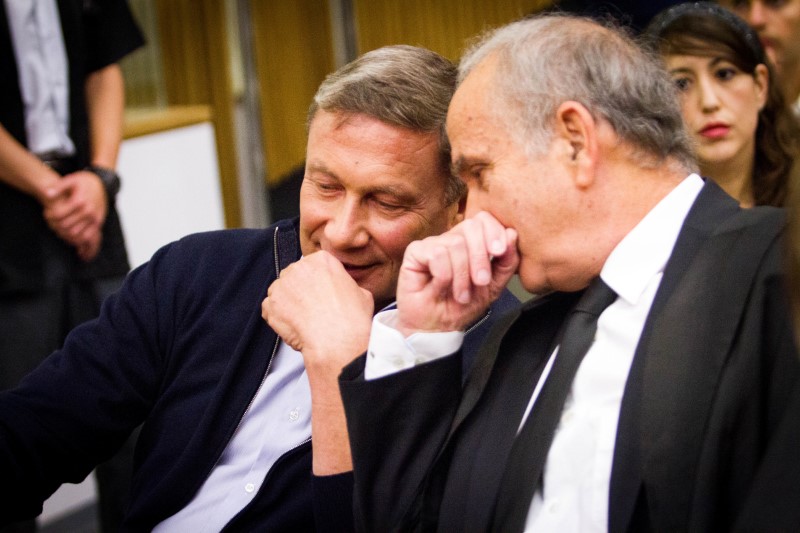 © Reuters. Nochi Dankner (L), once one of Israel's most powerful businessmen, attends a sentencing hearing at the Tel Aviv District court, Israel