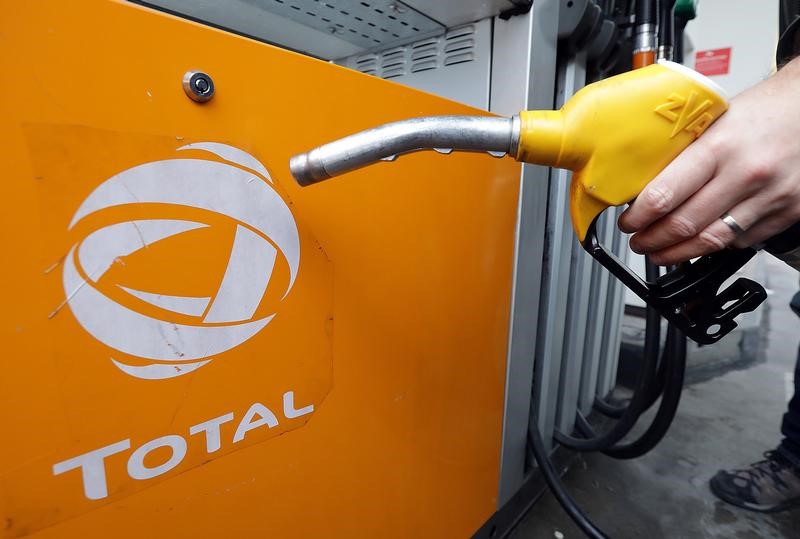 © Reuters. A customer holds a gas pump as he fills-up his car in a Total station in Nice