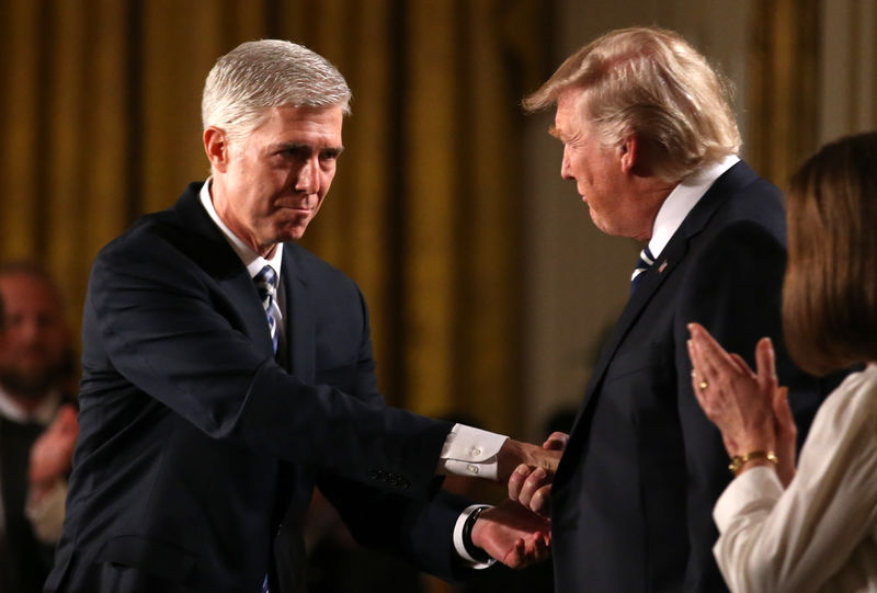 © Reuters. Judge Neil Gorsuch shakes hands with U.S. President Donald Trump as Gorsuch's wife Louise applauds after President Trump nominated Gorsuch to be an associate justice of the U.S. Supreme Court at the White House in Washington