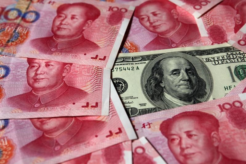 © Reuters. FILE PHOTO: A U.S. $100 banknote is placed next to 100 yuan banknotes in this picture illustration taken in Beijing