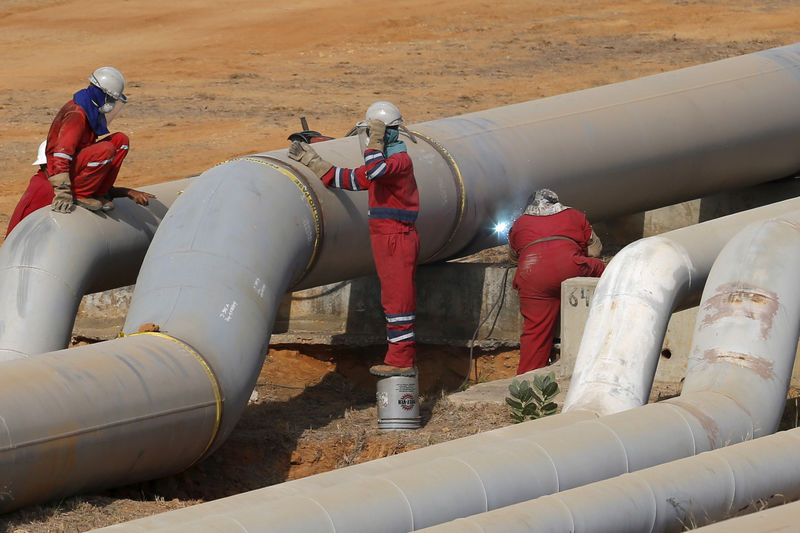 © Reuters. FILE PHOTO: Oil workers weld a pipeline at PDVSA's Jose Antonio Anzoategui industrial complex in the state of Anzoategui