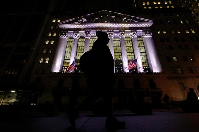 © Reuters. A commuter passes by the NYSE in the financial district in New York