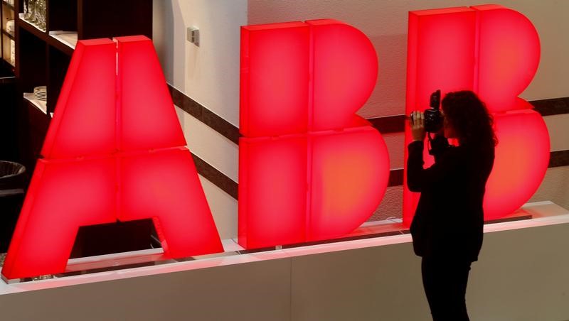 © Reuters. A woman takes pictures of the logo of Swiss power technology and automation group ABB in Zurich