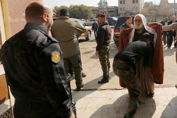 © Reuters. Forças de segurança iraquianas revistam pessoas do lado de fora de mesquista em Mosul