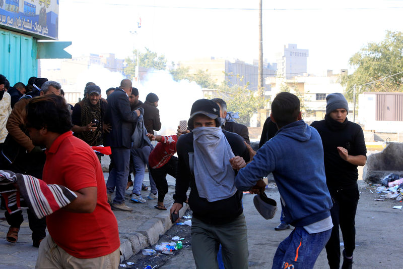 © Reuters. Iraqi security forces fire tear gas after supporters of Iraqi Shi'ite cleric Moqtada al-Sadr tried to approach the heavily fortified Green Zone during a protest at Tahrir Square in Baghdad