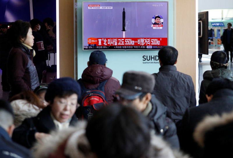 © Reuters. Passengers watch a TV screen broadcasting a news report on North Korea firing a ballistic missile into the sea off its east coast, at a railway station in Seoul