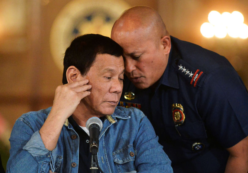 © Reuters. Philippine National Police chief General Ronald Dela Rosa whispers to President Rodrigo Duterte during the announcement of the disbandment of police operations against illegal drugs at the Malacanang palace in Manila