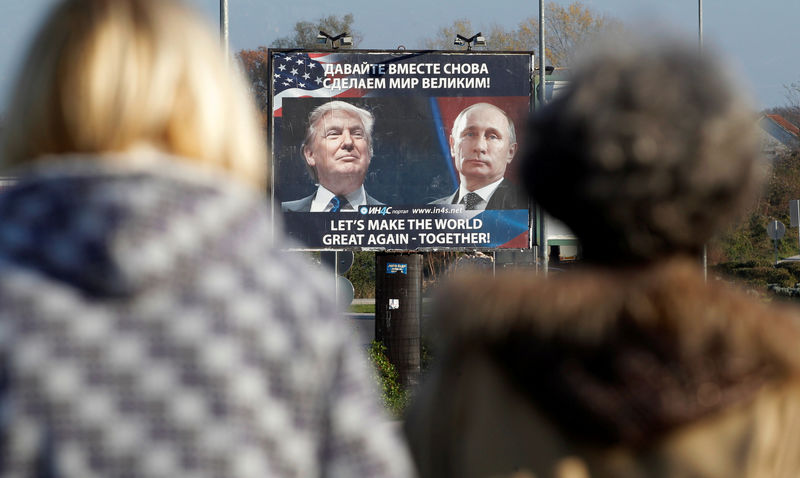 © Reuters. FILE PHOTO: A billboard showing a pictures of US president-elect Donald Trump and Russian President Vladimir Putin is seen through pedestrians in Danilovgrad