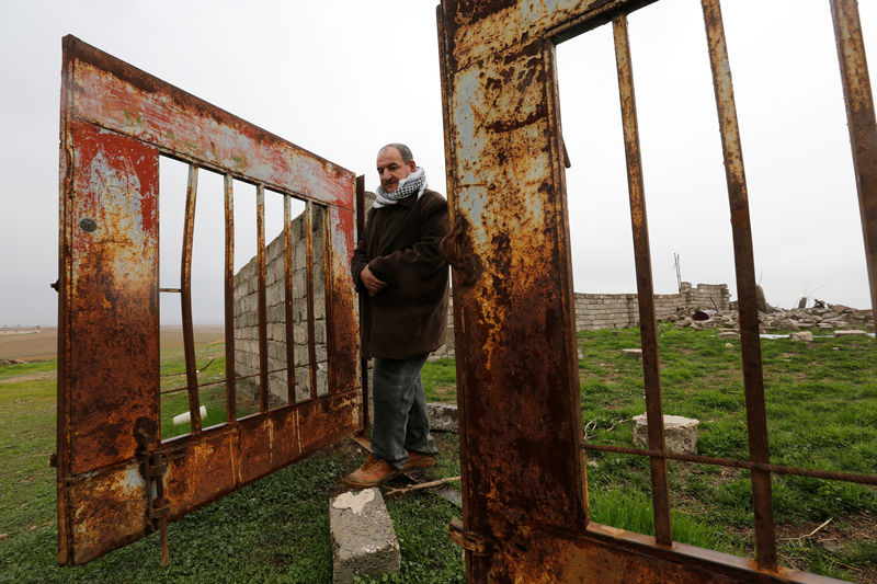 © Reuters. Farmer Sami Yuhanna inspects his farm that contains buildings destroyed by clashes in Qaraqosh,