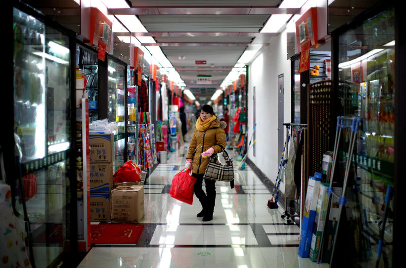 © Reuters. FILE PHOTO -  A woman pauses as she shops at a wholesale market in Yiwu