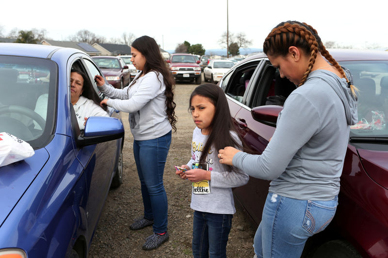 © Reuters. Violet Orozco has her hair brushed by her sister Bertha at a Red Cross relief center in Chico, California, after an evacuation was ordered for communities downstream from the Lake Oroville Dam, in Oroville